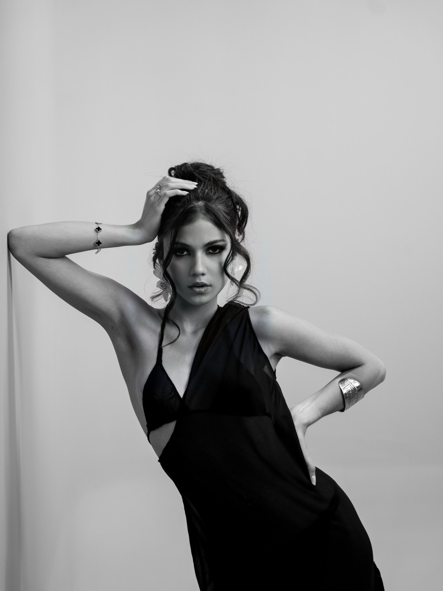 Modelo con vestido negro drapeado, pose de autoridad, imagen editorial DINAMITA
